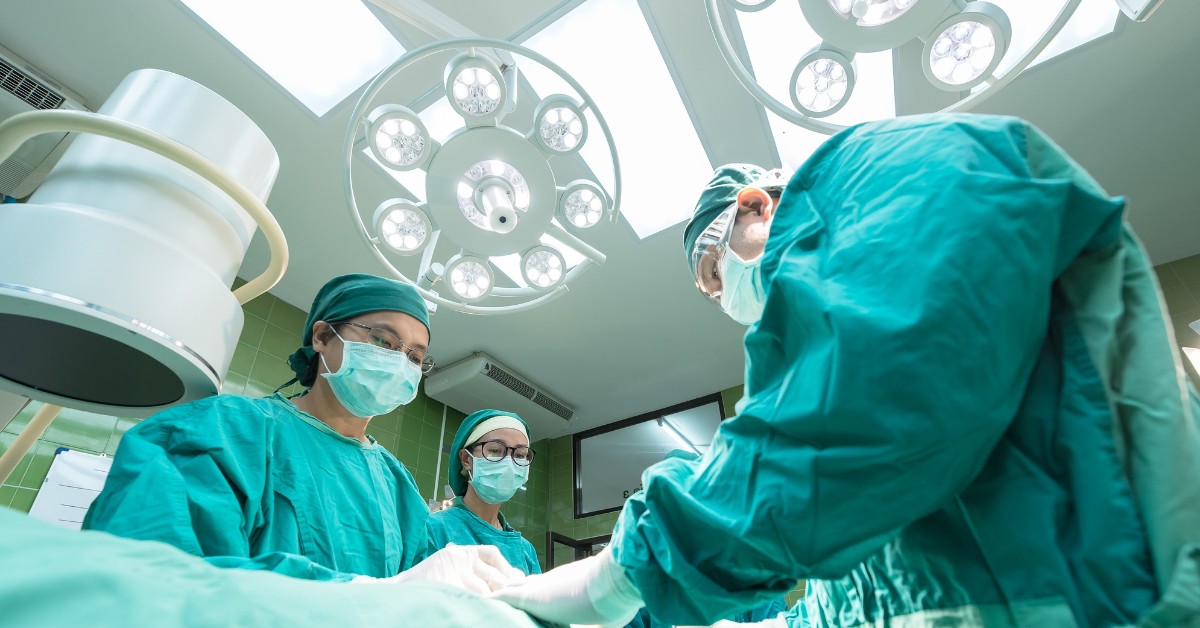 Surgeons performing an operation under bright surgical lights.