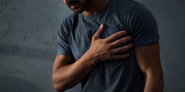 Man in pain holding his chest